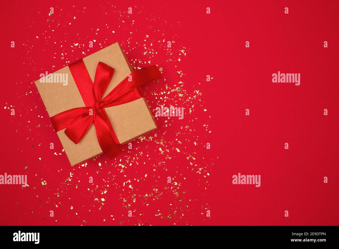 Gift box with red bow on luxury red background with golden sparkles ...