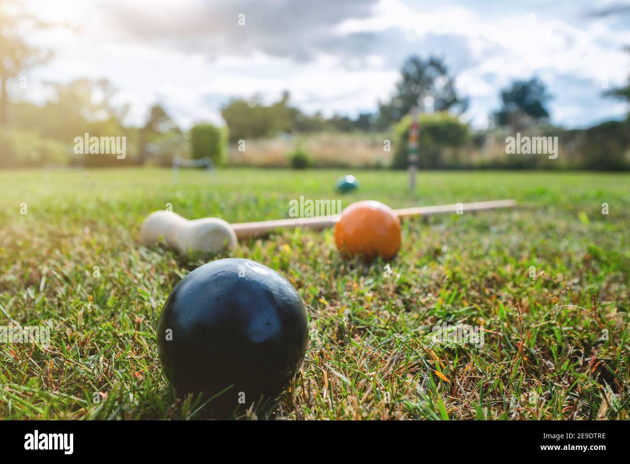Croquet outdoor game on a lawn in the summer with a mallet and colorful