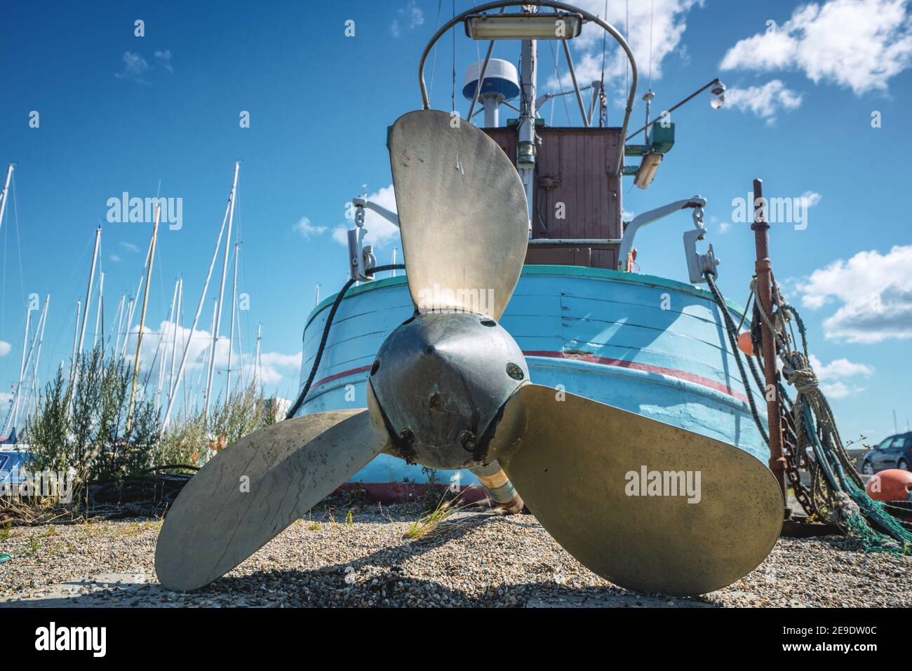 Fishing boat with a large propeller on land at a marine harbor in