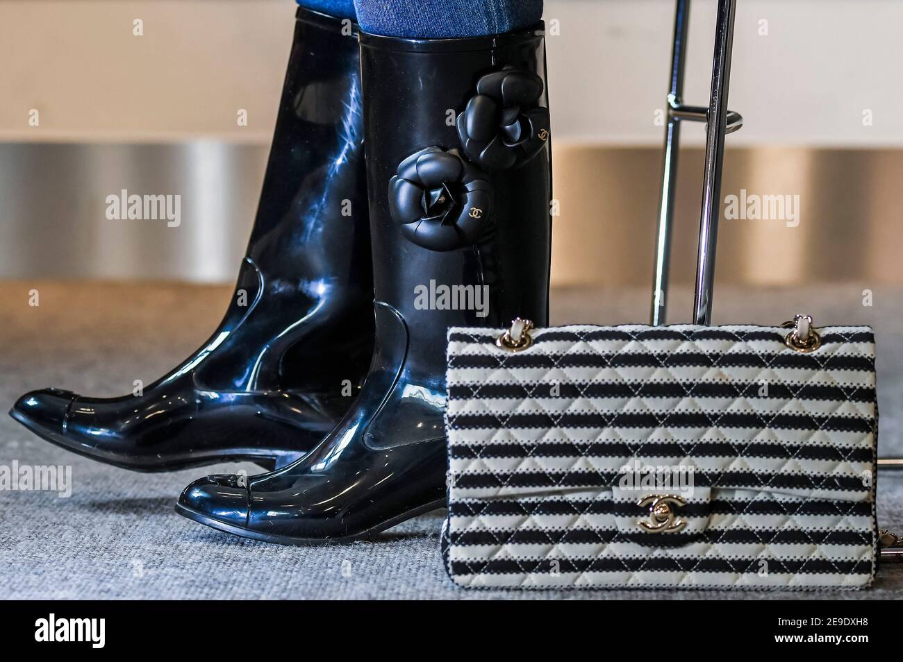 London, UK. 4 Feb 2021. Designer Wellington Boots by Chanel with Camellia  design (part of a set of 2 pairs) est £200-300 with a Black and White Coco  Sailor Flap Bag, Cruise
