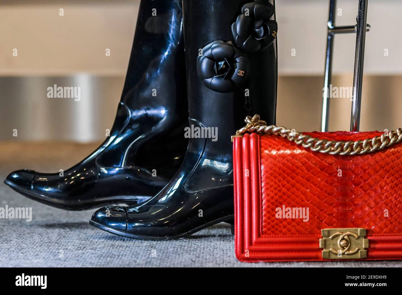 London, 4th Feb, 2021. Designer Wellington Boots by Chanel with Camellia design (part of set 2 pairs) est £200-300 with a Red Python Boy Bag, Chanel, c. 2014,