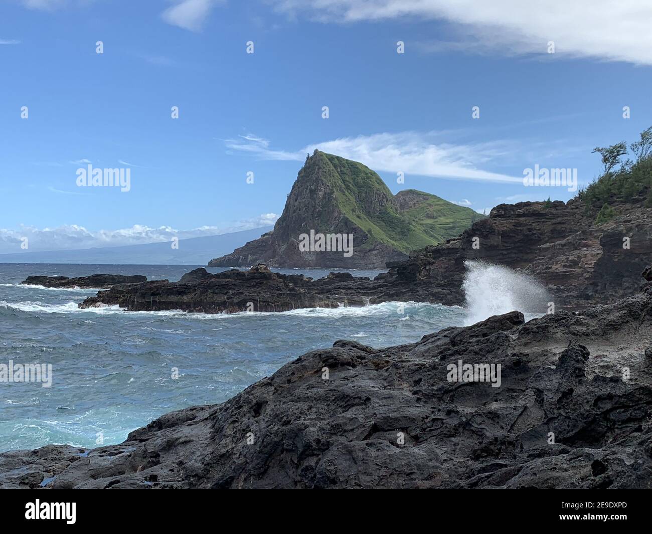 Coastline view of the volcanic rocks in the ocean splashing at the cove
