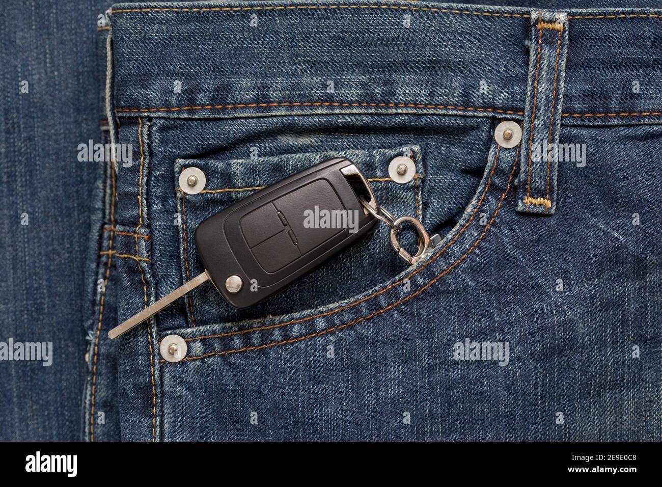 Ignition key is lying in side pocket of blue jeans. Modern lifestyle
