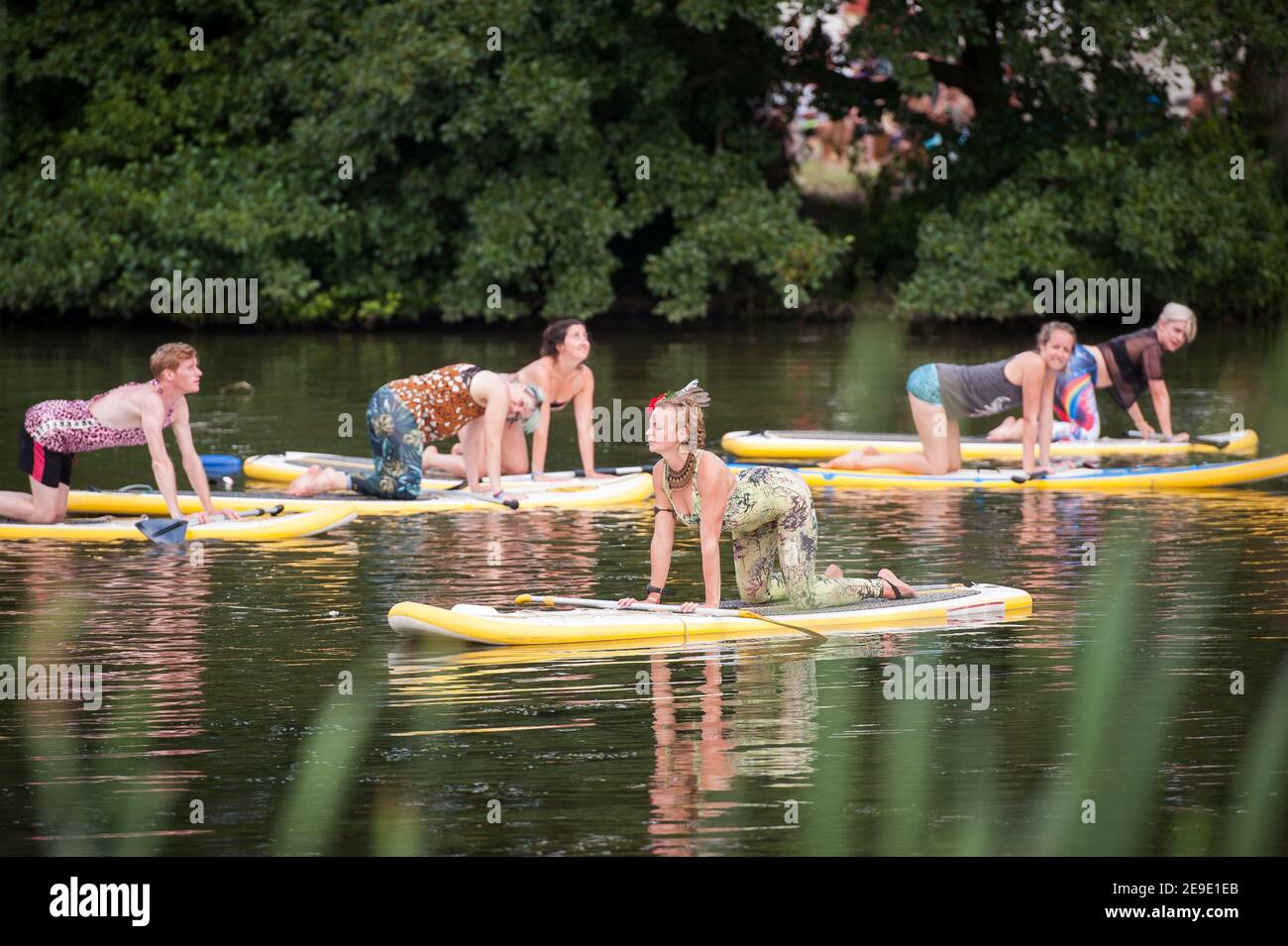 Paddle board Yoga on a lake at Shambala Festival, Kelmarsh, Nothamptonshire, UK Stock Photo