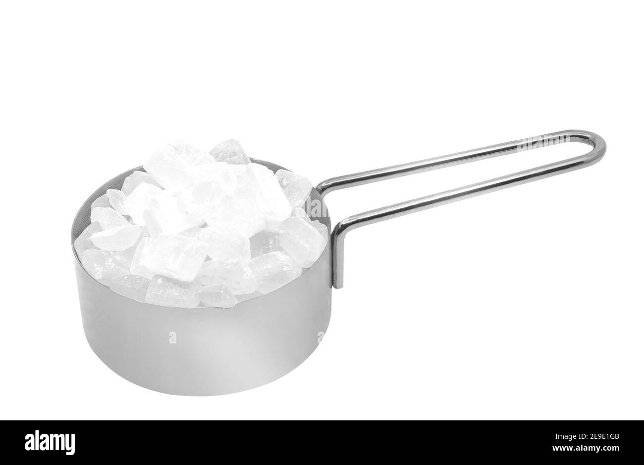Isolated rock sugar in metal measuring cup on white background. Close up stainless steel measuring cup with rock sugar. Stock Photo