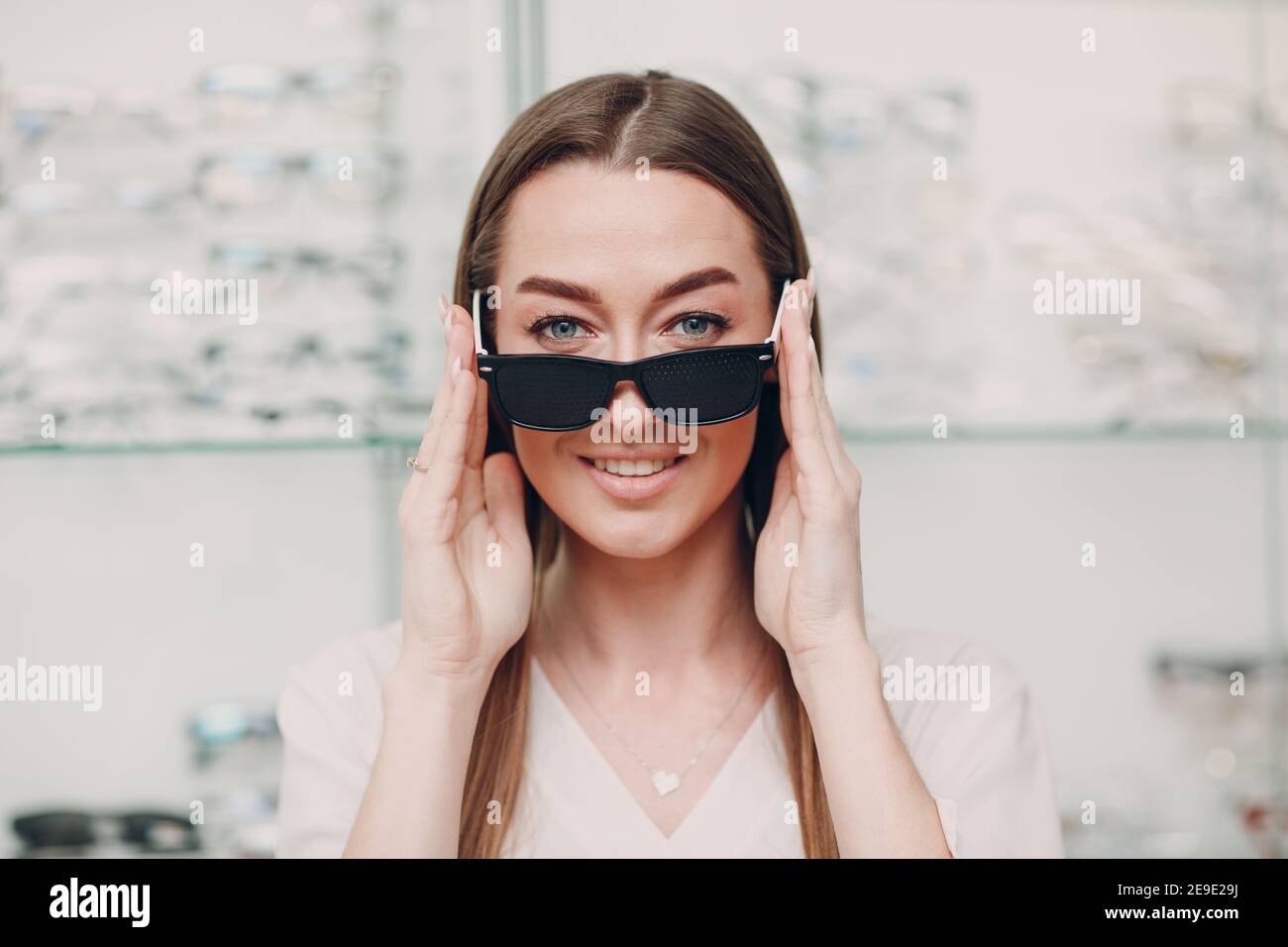 Young Woman with Black punched eyeglasses for vision training. perforated  glasses trainer Stock Photo - Alamy