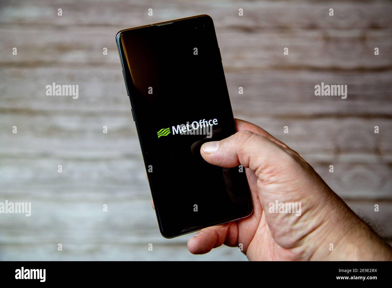 A hand holding a Mobile phone or cell phone with the Met Office weather app on screen Stock Photo