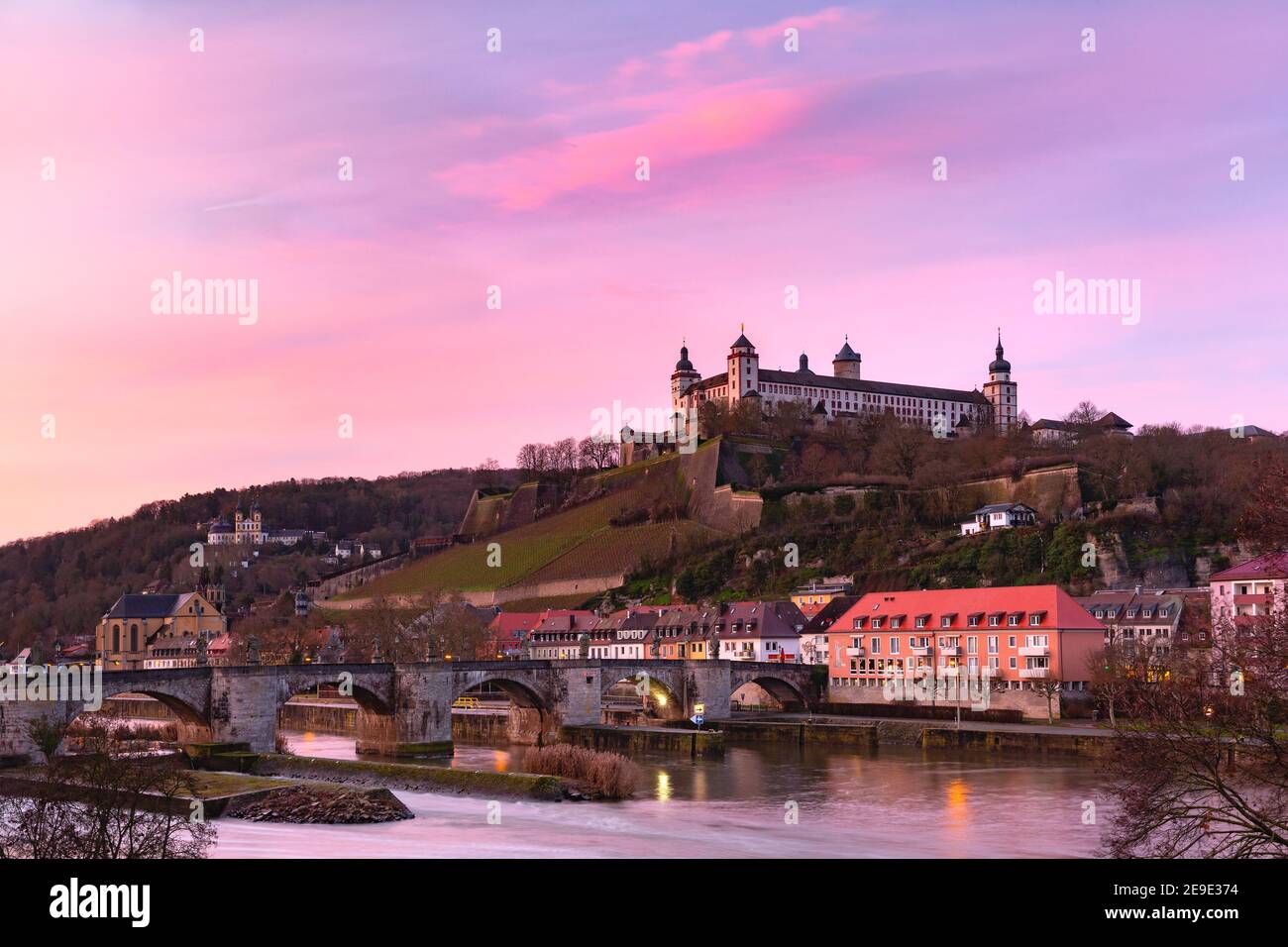 View of Marienberg Fortress and Old Main Bridge, Alte Mainbrucke in Wurzburg at pink sunset, Bavaria, Germany Stock Photo