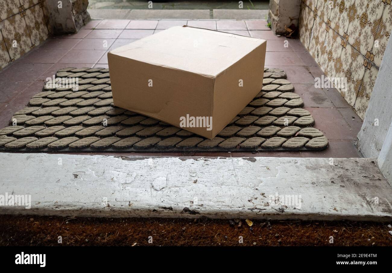 Contactless online home delivery as part of Covid-19 safety measure where the package is left by the door with no personal contact. Stock Photo