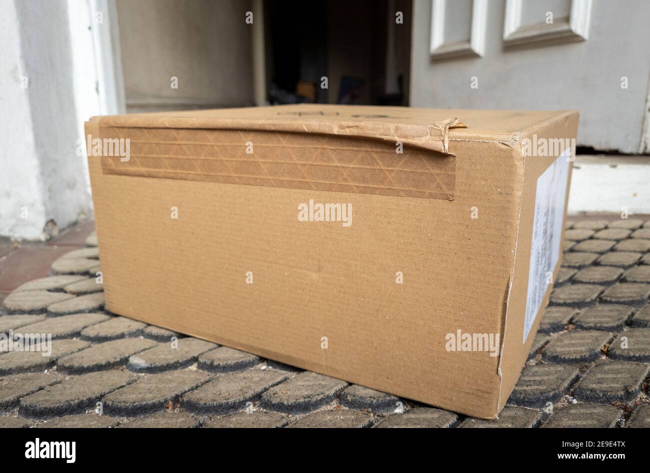 Contactless online home delivery as part of Covid-19 safety measure where the package is left by the door with no personal contact. Stock Photo