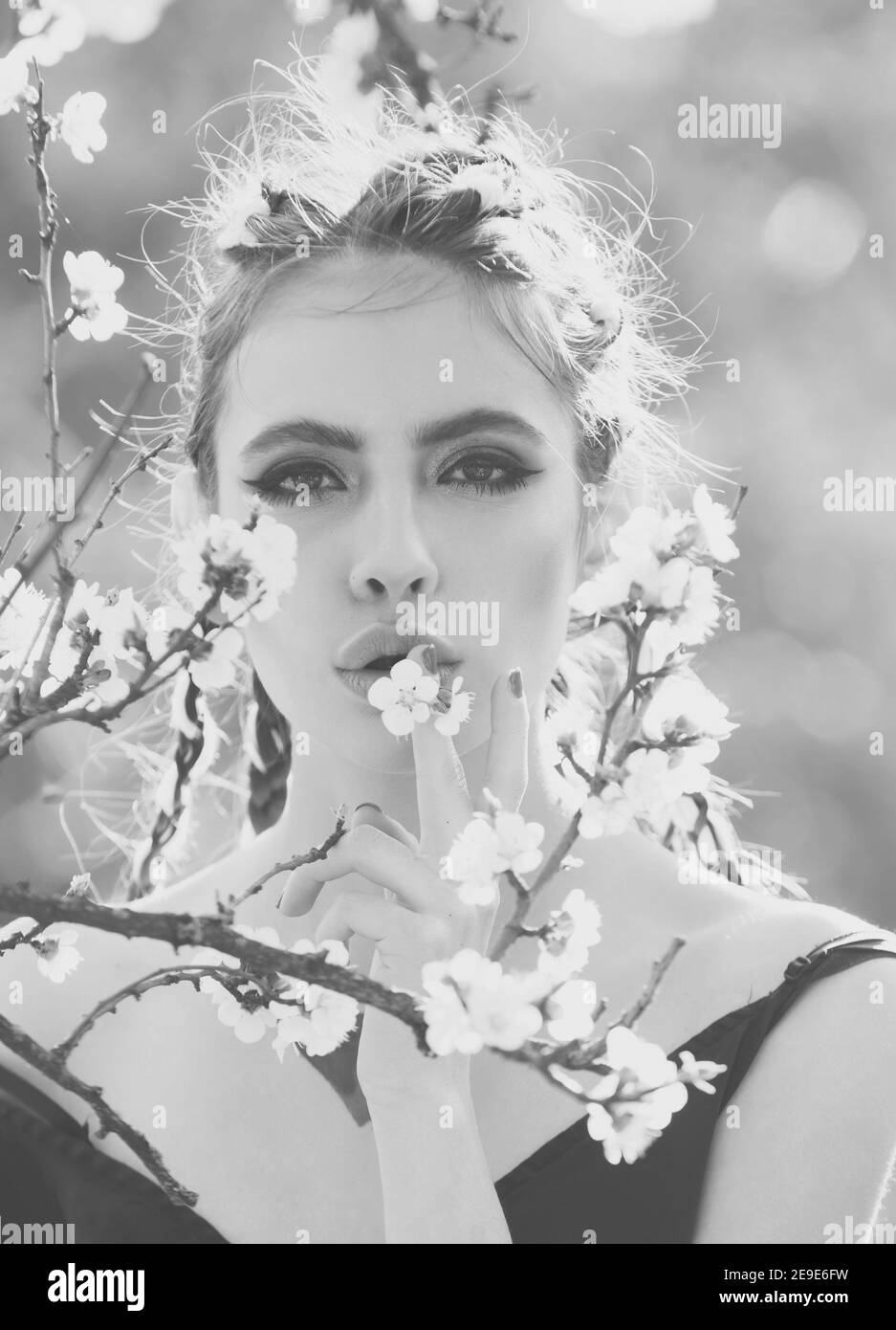 Beautiful girl in spring park with flowers. Black white. Stock Photo