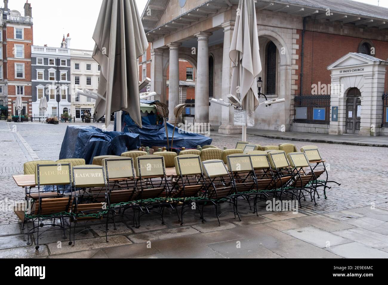 According to the government's Covid social distance restrictions, tables and chairs from a closed restaurant business 'Laduree' are stacked and tied together in the Covent Garden Piazza during the third lockdown of the Coronavirus pandemic, on 3rd February 2021, in London, England. Stock Photo