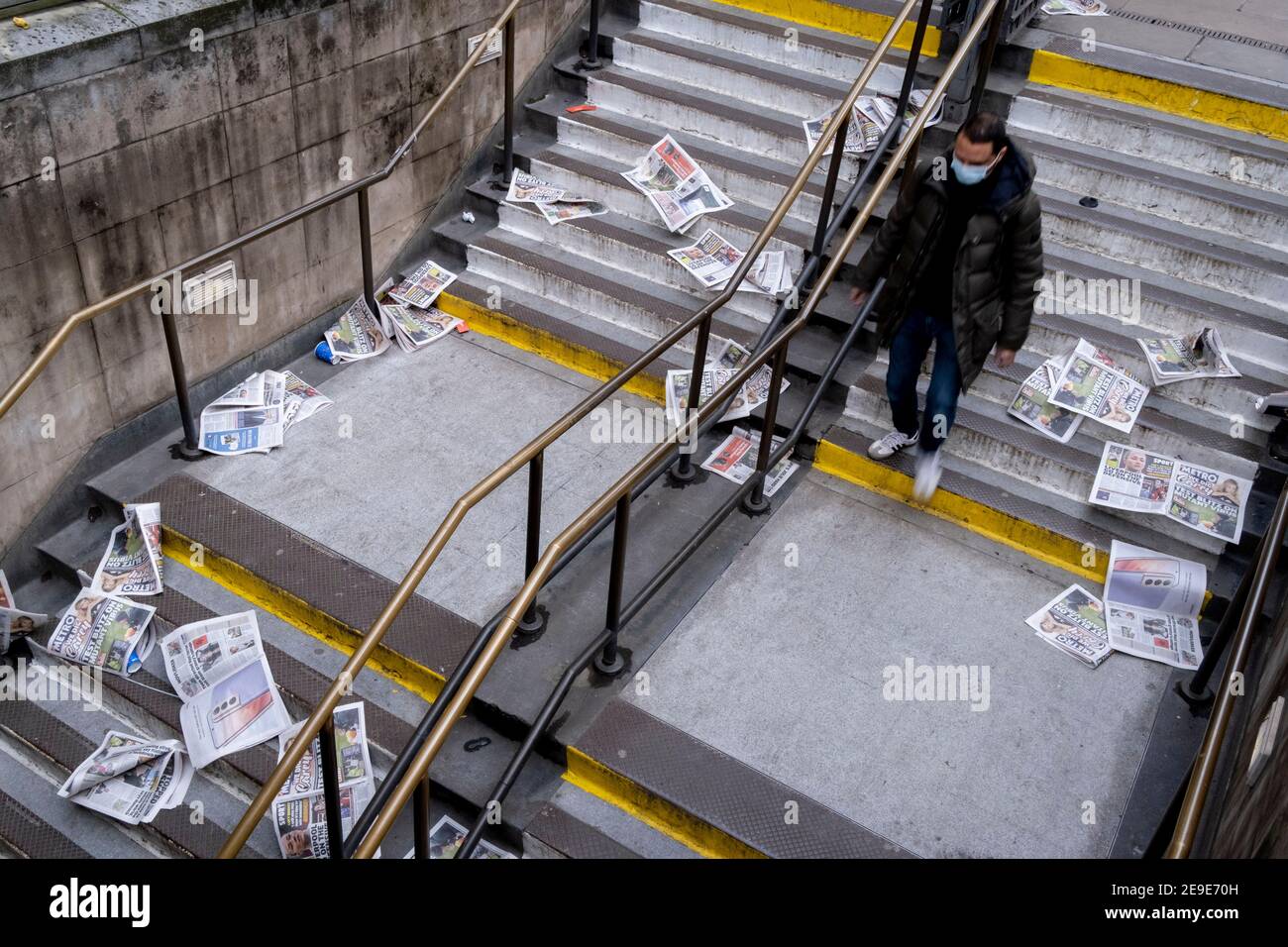 As Londoners are told to remain at home and therefore few commuters taking newspapers for their homeward journeys, copies of the Evening Standard blow down the steps of Bank Underground station during the third lockdown of the Coronavirus pandemic, in the 'City of London', the capital's financial district, aka The Square Mile, on 2nd February 2021, in London, England. Stock Photo