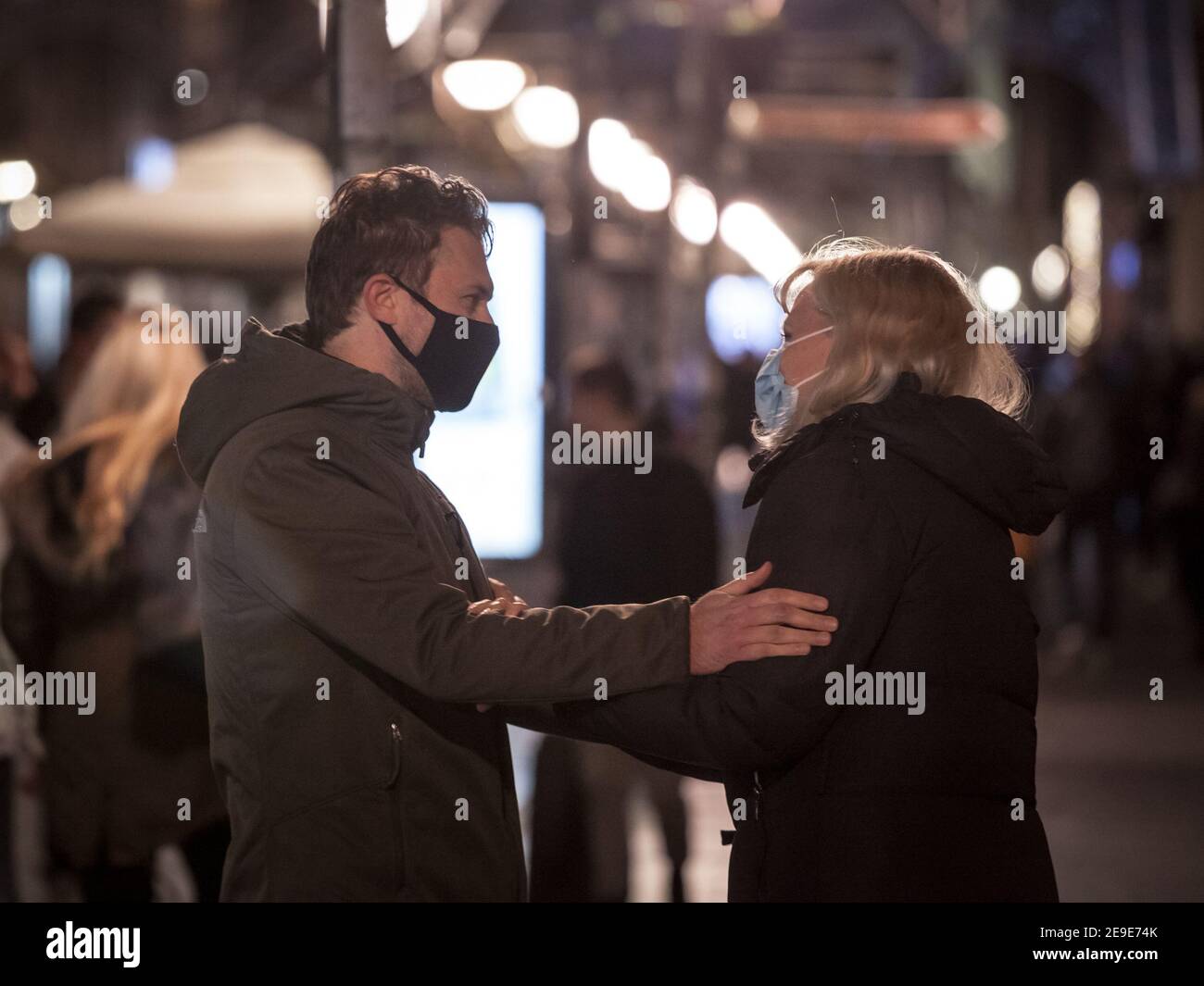 BELGRADE, SERBIA - NOVEMBER 11, 2020: Couple of lovers, man and woman hugging and showing affection wearing a face mask in Kneza Mihailova street of B Stock Photo