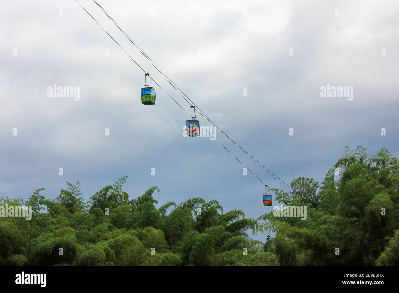 Cable car moving high above green colombian rainforest Stock Photo