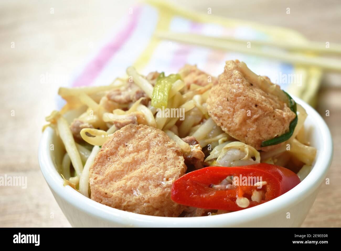 fried bean sprout with slice egg tofu and chop pork in cup on table