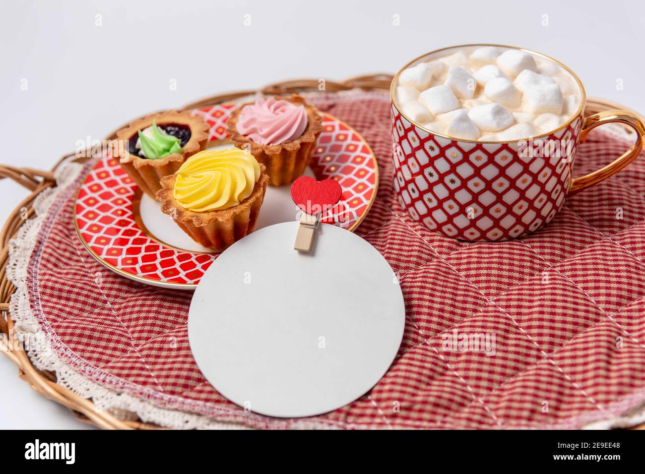 Caked with cream and a cup of hot cocoa with marshmallows. A place to greet the heart on the clothespin. Stock Photo