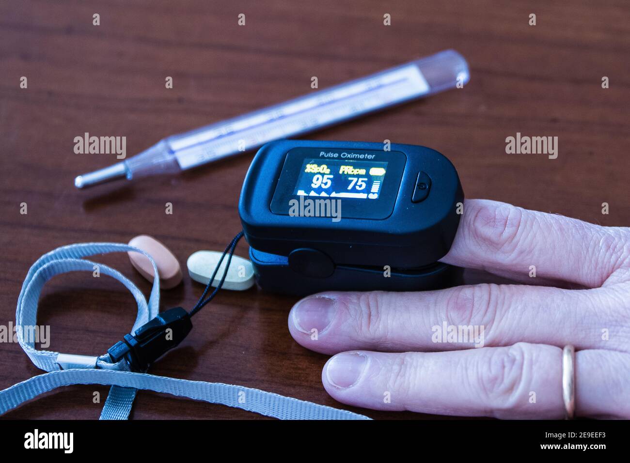 Measuring saturation with a finger pulse oximeter during coronavirus positivity Stock Photo