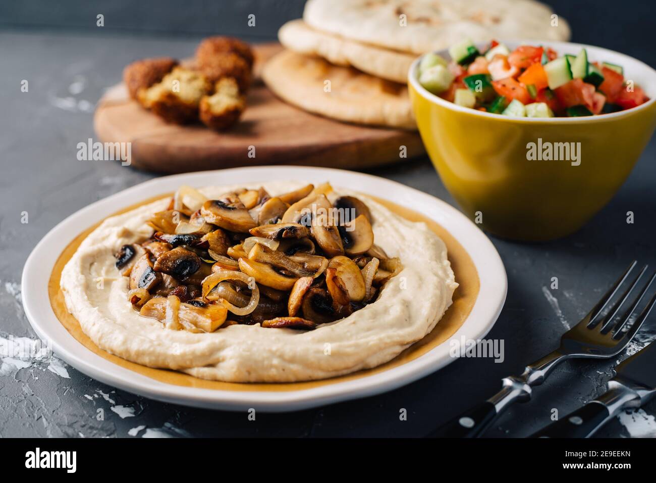 Hummus with fried mushrooms, cucumber and tomato salad, falafel and
