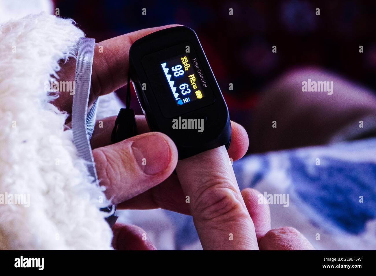 Measuring saturation with a finger pulse oximeter during coronavirus positivity Stock Photo