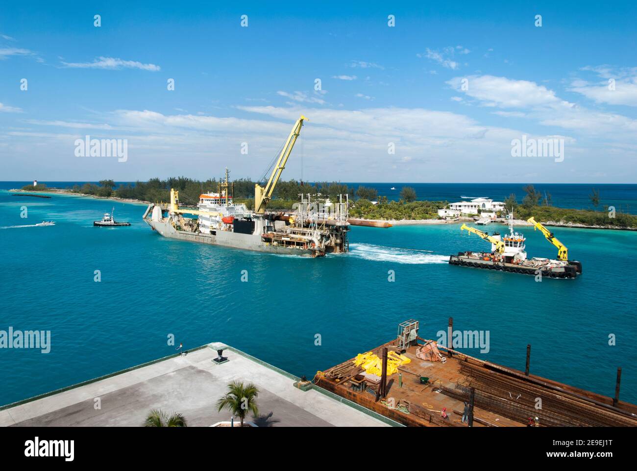 The aerial view of a tugboat pulling the large industrial ship with a
