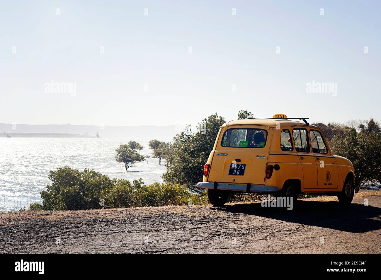 Yellow R4 on the road by the sea on northern tip of the island Madagascar Stock Photo