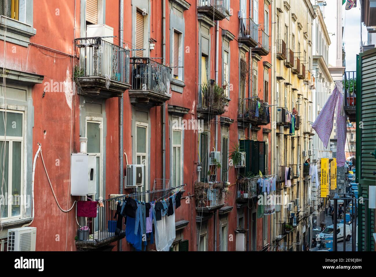 Naples, Italy - September 6, 2019: Facade of classic buildings with hanging clothes and women on the balcony in the historical center of Naples, Italy Stock Photo