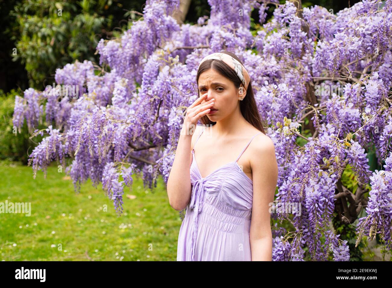 Spring allergy nose sneezing. Allergic symptoms. Woman allergic to blossom. Stock Photo
