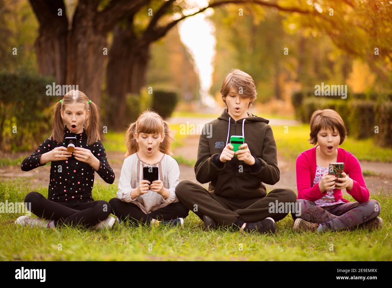 Group Of Curious Kids Using Mobile Phone Device Together Telephone Addiction Nomophobia Stock Photo Alamy