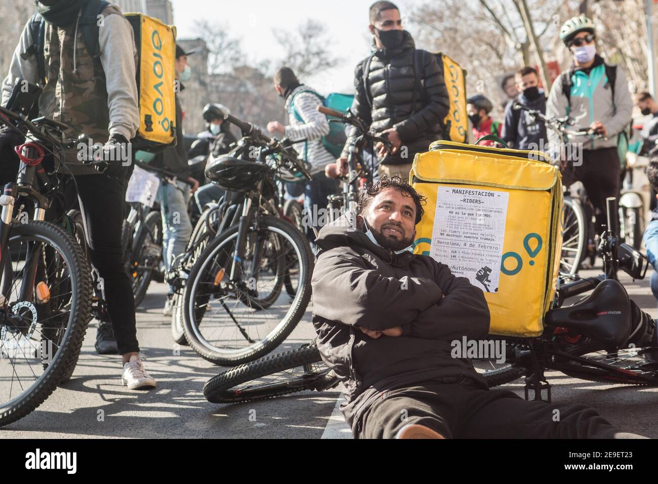 Barcelona, Catalonia, Spain. 4th Feb, 2021. Protester is seen on the avenue  floor with a bicycle and a Glovo bag.Hundreds of delivery people from  different home delivery platforms such as Deliveroo, Uber