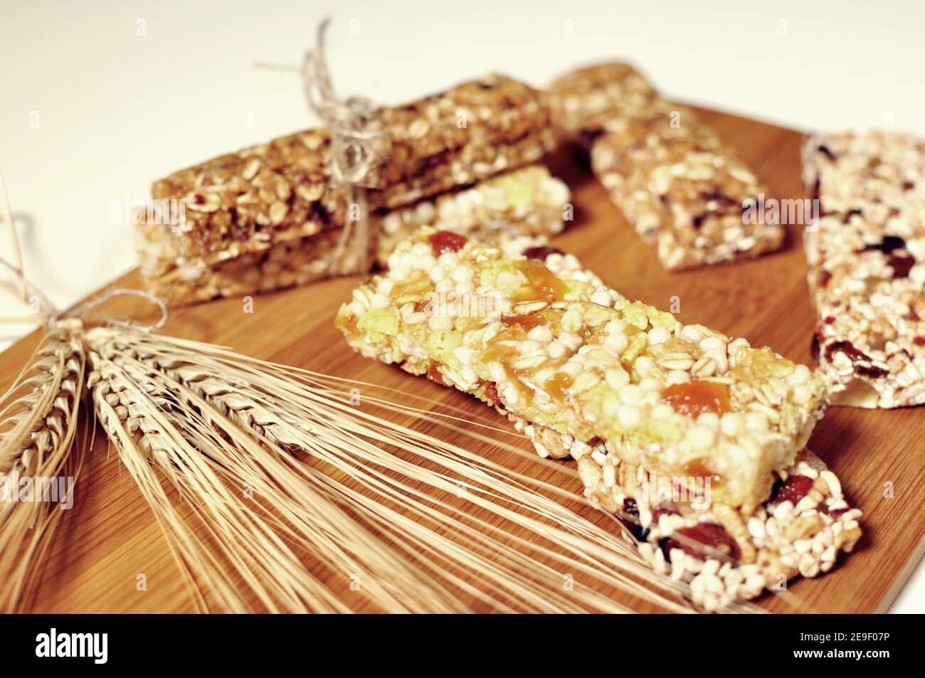 Bars of healthy cereal sweet snacks on wooden board. Top dish Stock Photo
