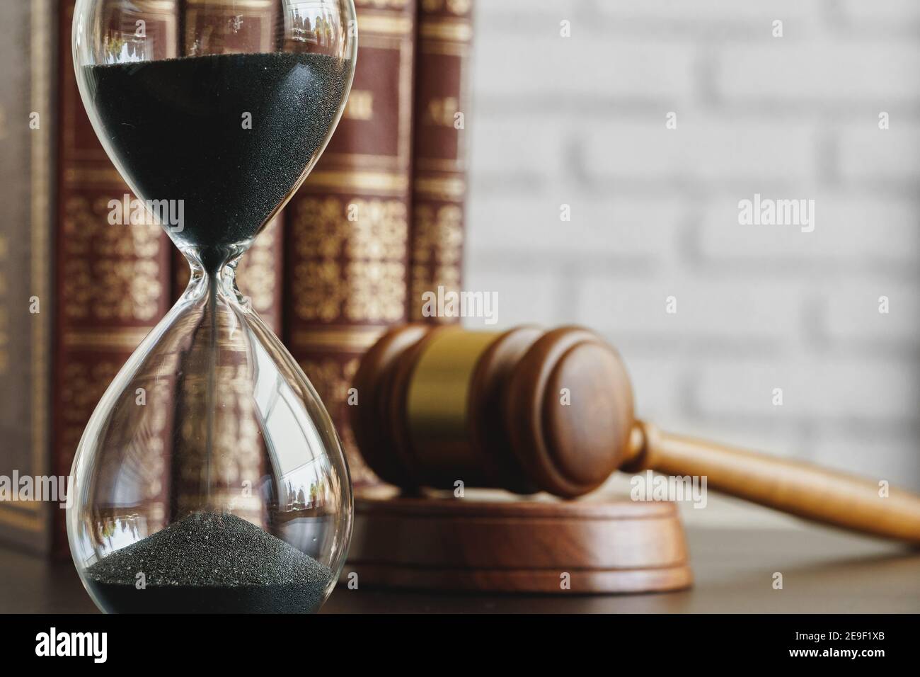 Court concept. Hourglass and judge gavel on table Stock Photo