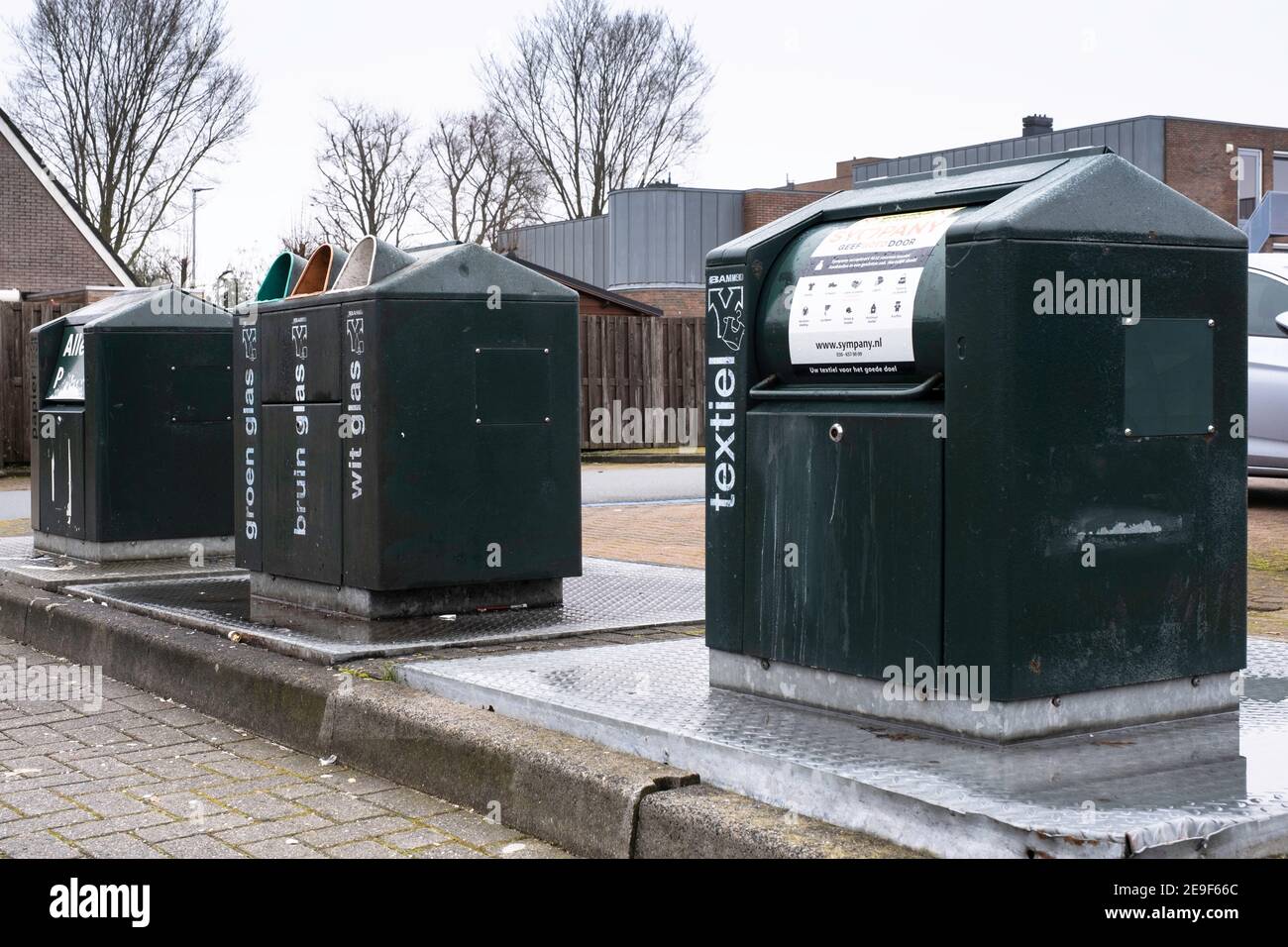 Underground waste containers for textiles, glass and paper in a parking lot at a supermarket
