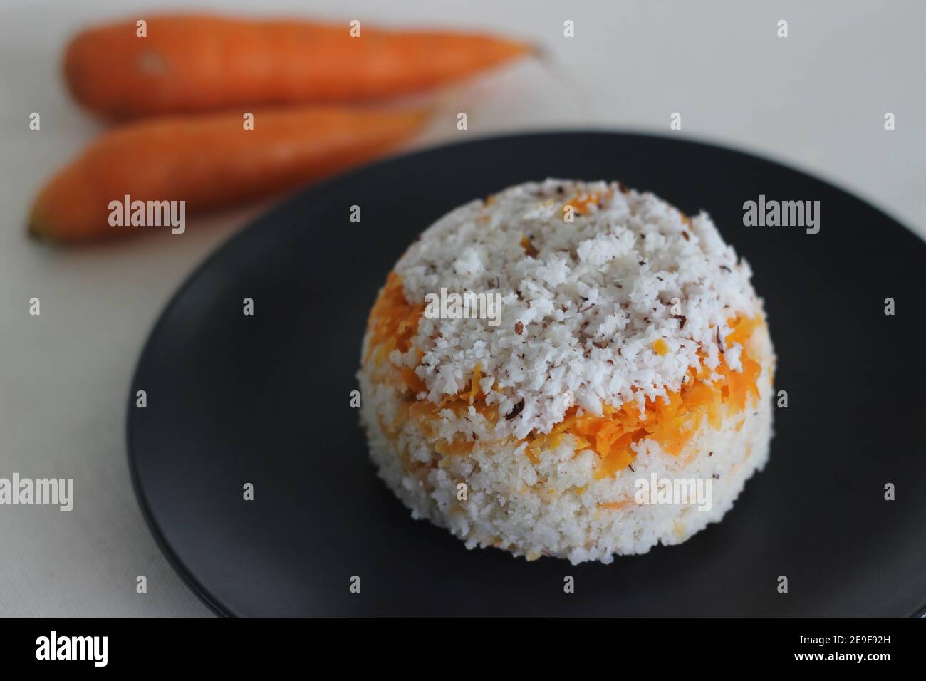 Carrot puttu. A variety of Kerala rice steam cake by adding shredded carrots along with rice flour and shredded coconut mixture Stock Photo