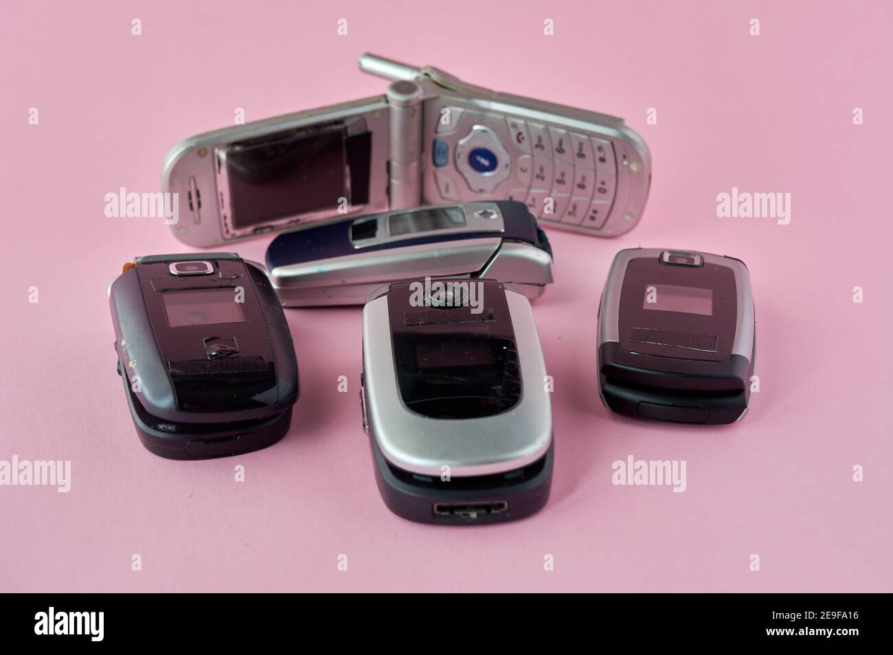 broken mobile phones, recycling technology, early 2000s on pink background and copy space,. Stock Photo