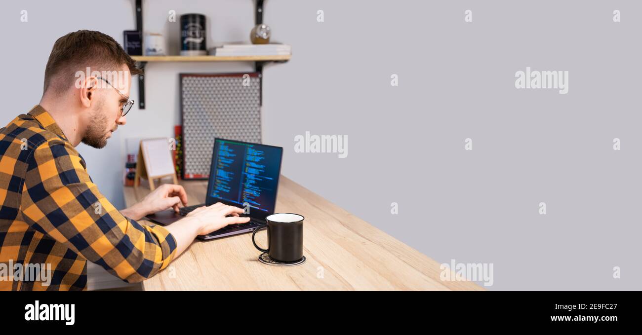 Portrait of male programmer using Programs computer code in a bright Home. Concept programmer Day Stock Photo