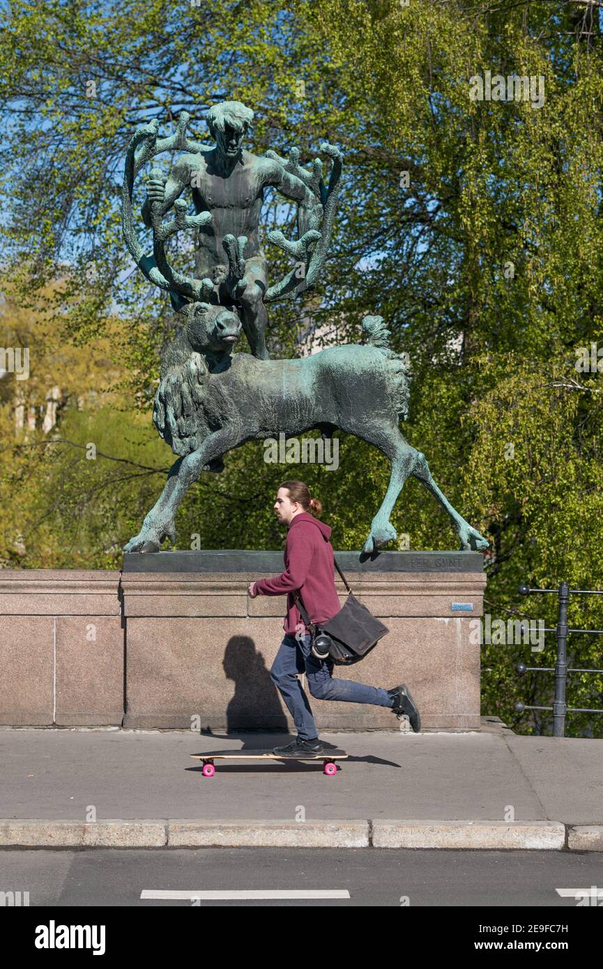A young man skateboards beneath the Statute of Per Gynt by Dyre Vaa, Ankerbrua, Torggata, Oslo, Norway. Stock Photo