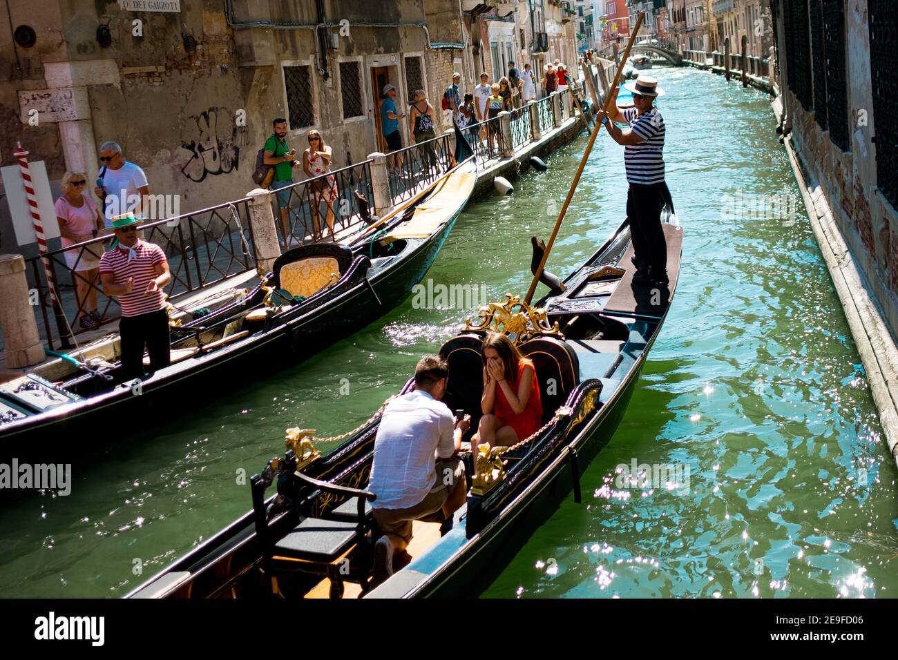 Venice, Italy - 20 , 2019: real marriage proposal on a gondola. romantic couple promising love and showing ring in venetian channel on a sunny summer Stock Photo