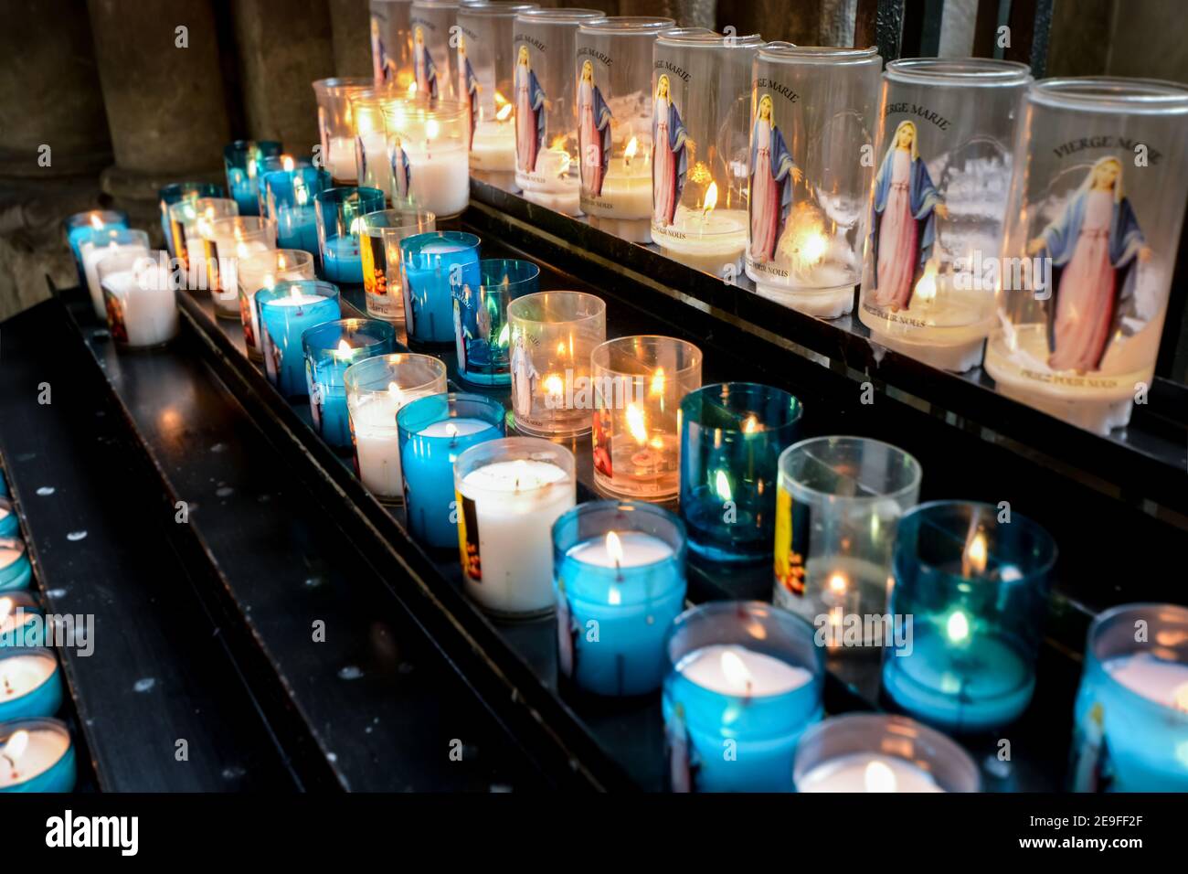 Prayer or votive candles with the image of vierge marie or the Virgin Mary  inside the Rouen Cathedral in Normandy, France Stock Photo