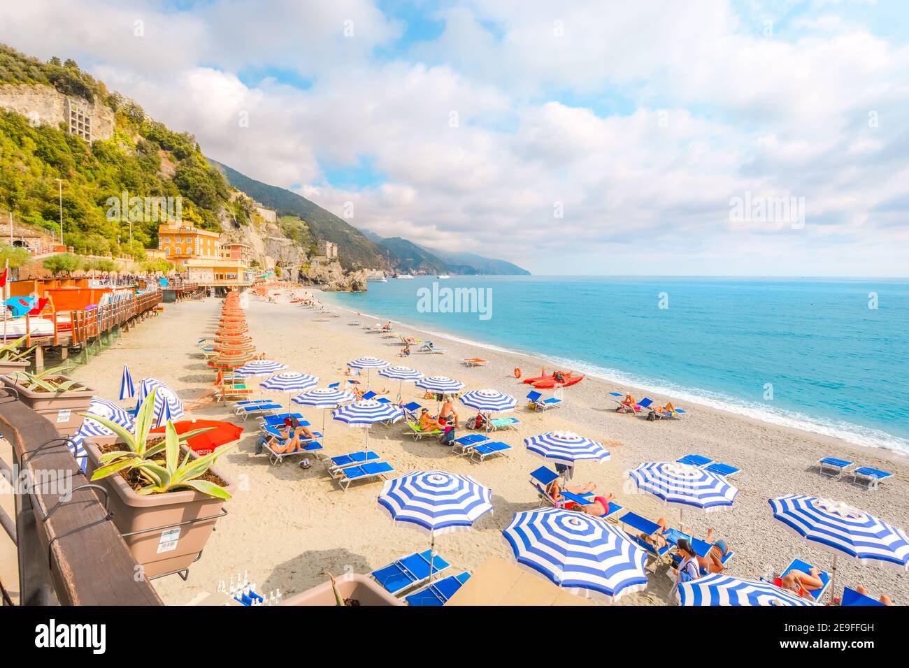 The sea and sandy beach Spiaggia di Fegina at the Cinque Terre Italy resort village of Monterosso al Mare with tourists enjoying the Italian Riviera Stock Photo