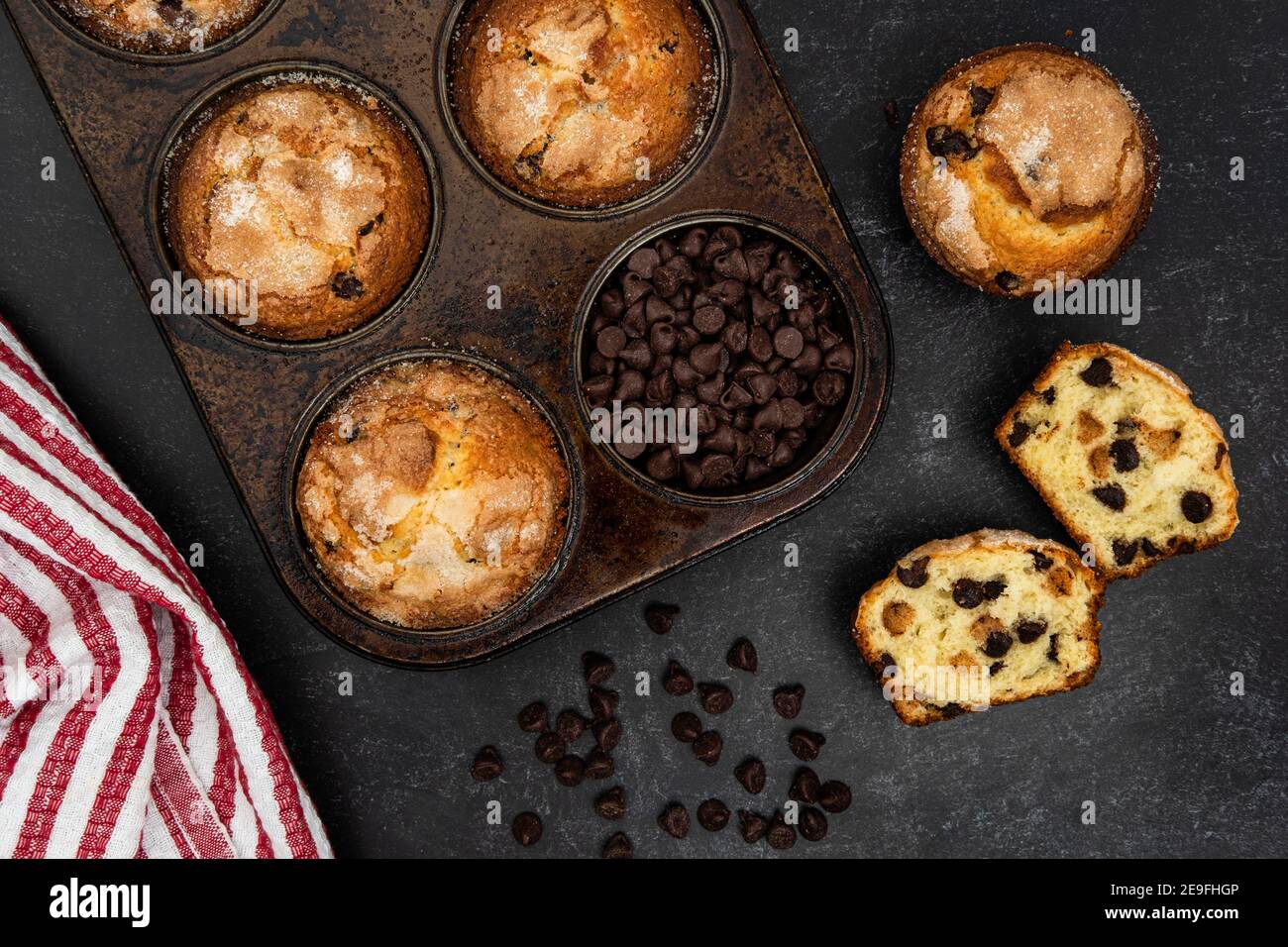 Chocolate chip muffins in a muffin tin and on the counter Stock Photo