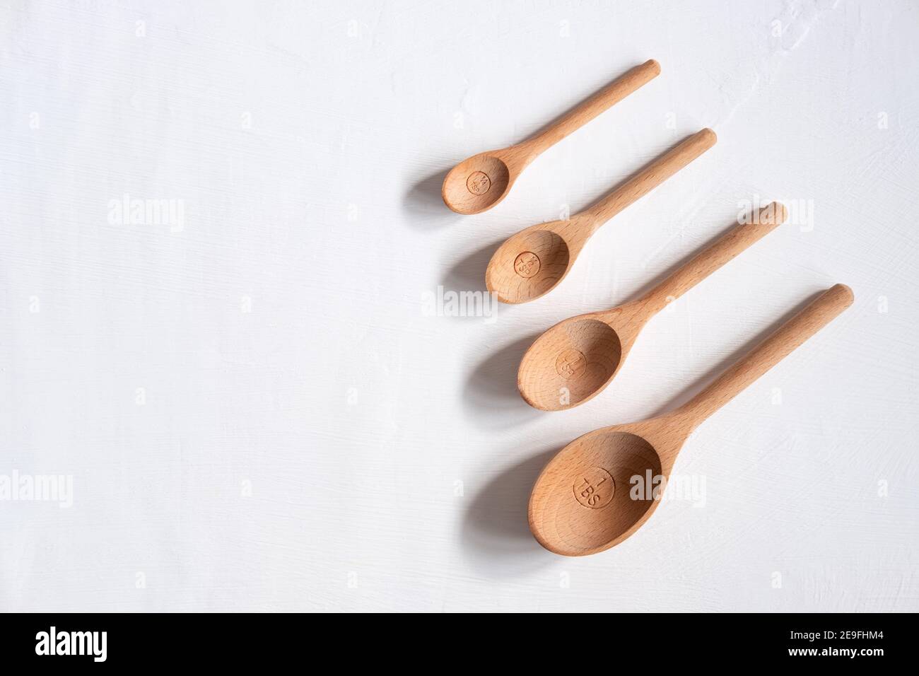 Wooden measuring spoons on a white background with copyspace Stock Photo