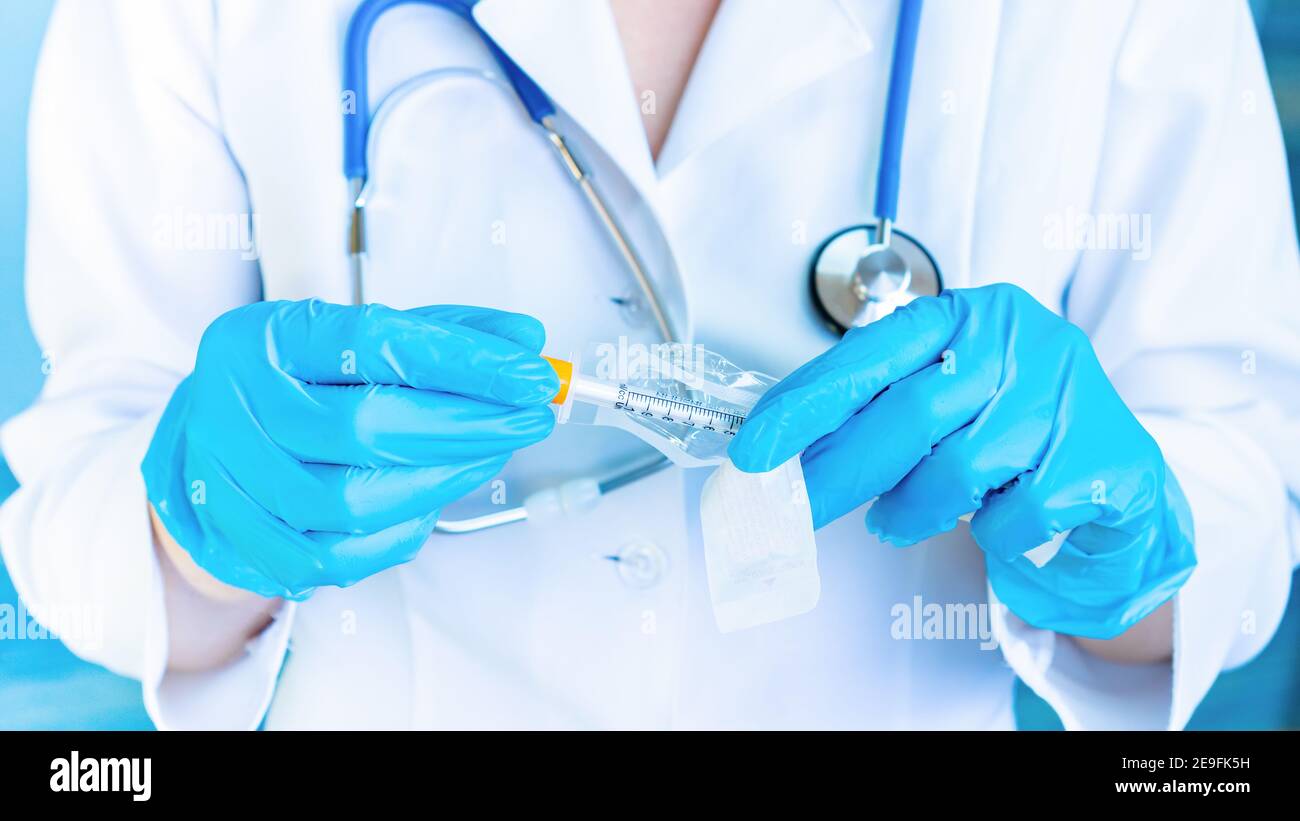 The doctor opens the package of the insulin syringe to give the