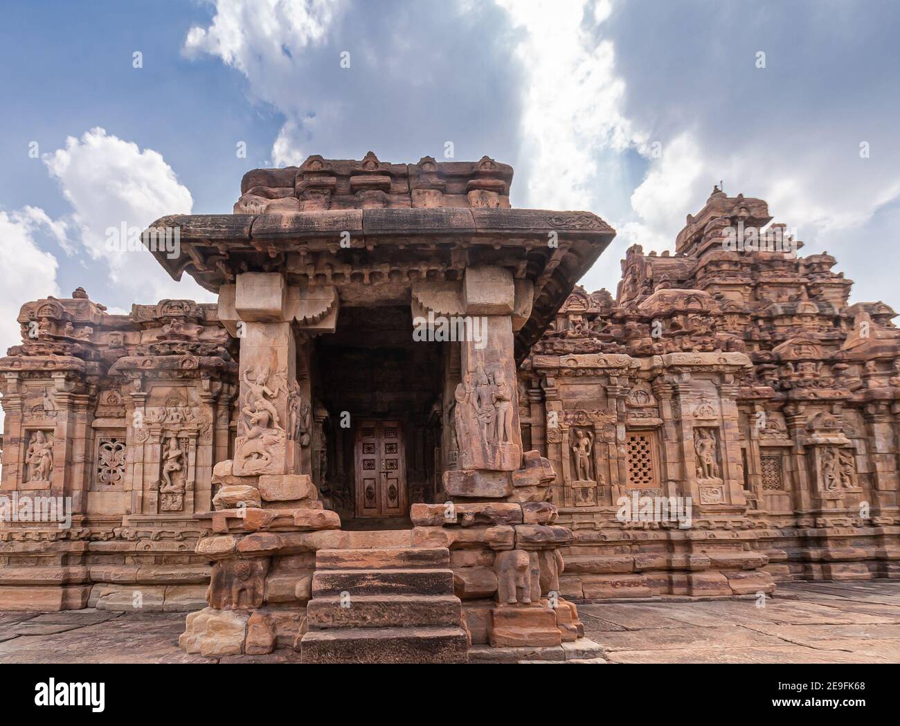 Bagalakote, Karnataka, India - November 7, 2013: Pattadakal temple complex. Monumnetal sculpted entrance of brown stone Viruipaksha temple under blue Stock Photo