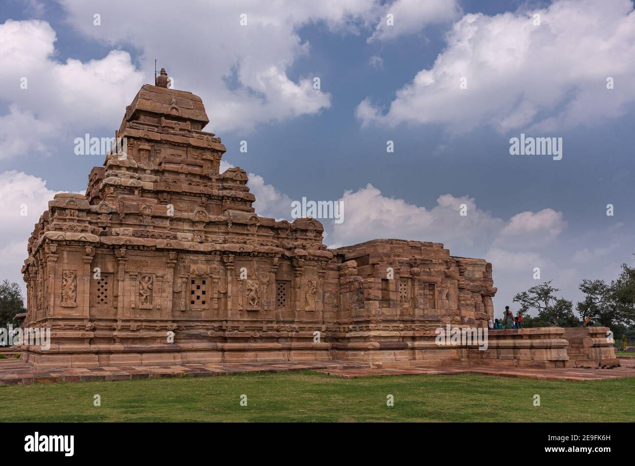 Bagalakote, Karnataka, India - November 7, 2013: Pattadakal temple complex. Side closeup of brown stone Virupaksha temple under blue cloudscape. Green Stock Photo