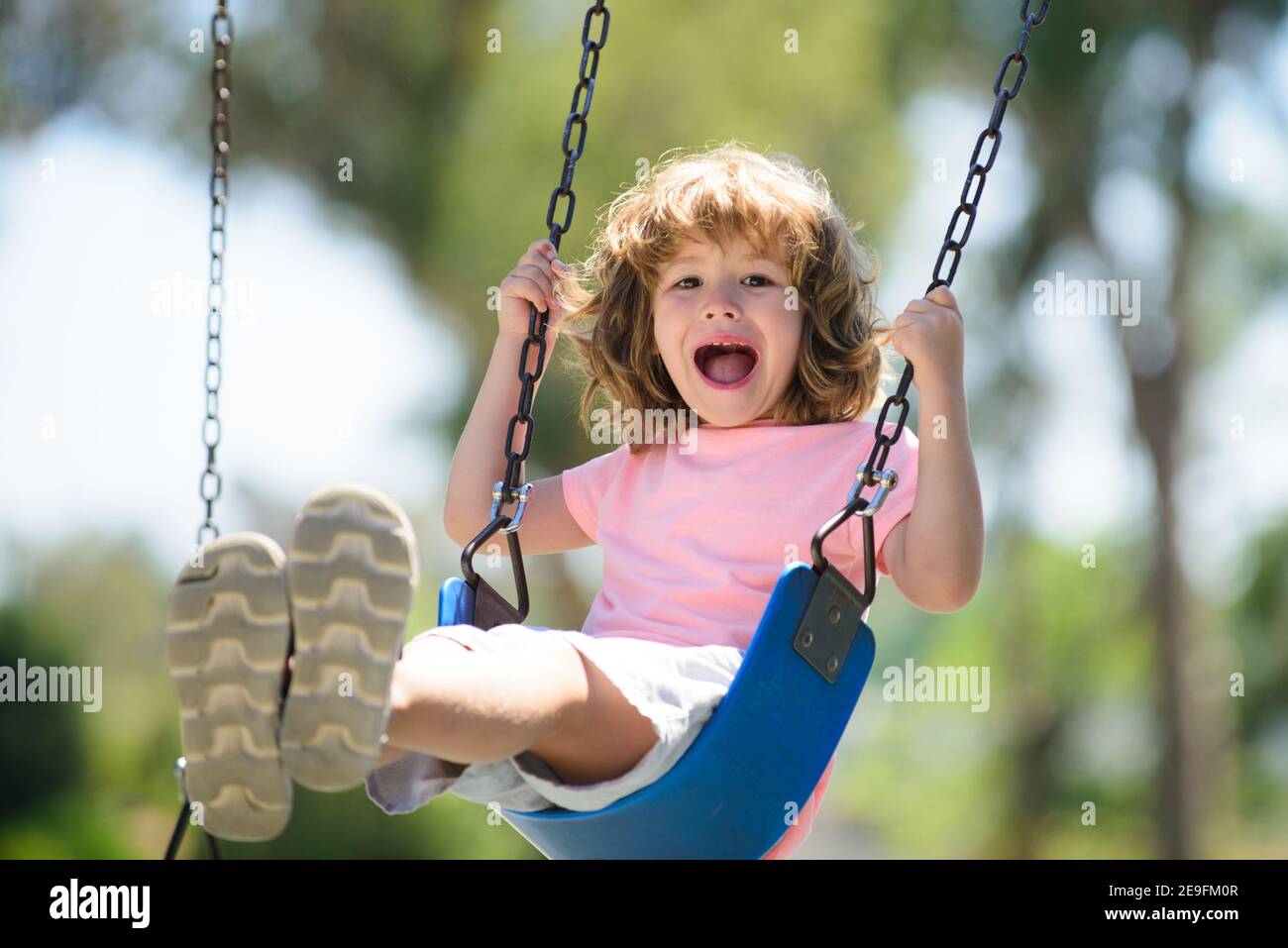 Child swing on backyard. Kid playing oudoor. Happy cute little boy ...