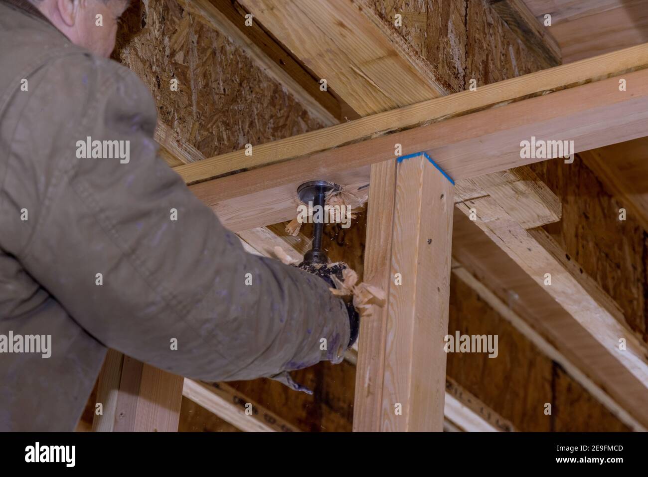 Pumping contractor for drilling hole in joist for ABS and PVC drain