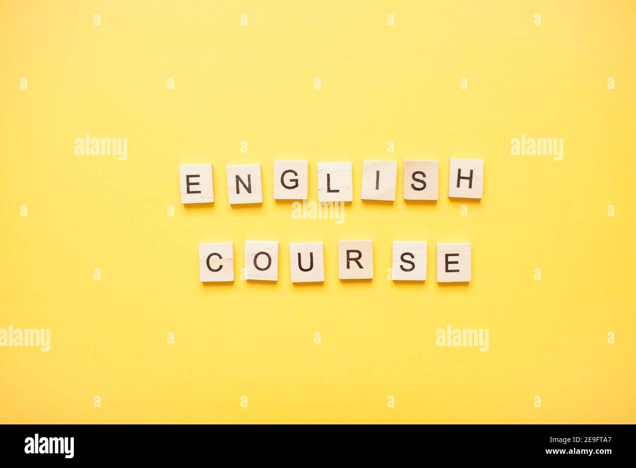 Phrase english course made from wooden blocks on a light yellow background Stock Photo