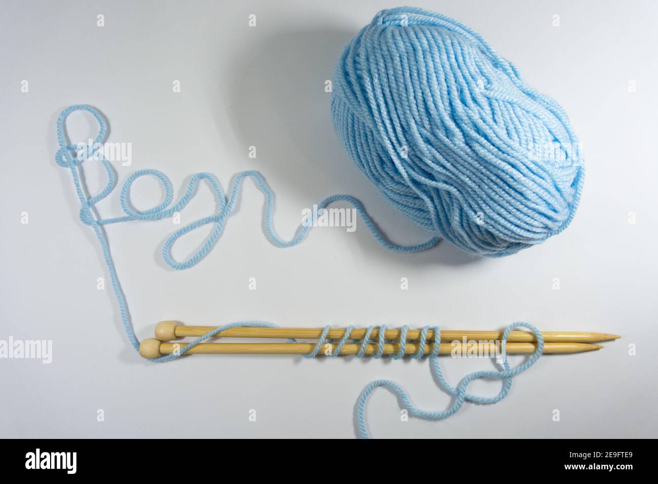 Blue yarn ball with knitting needles on white background Stock Photo