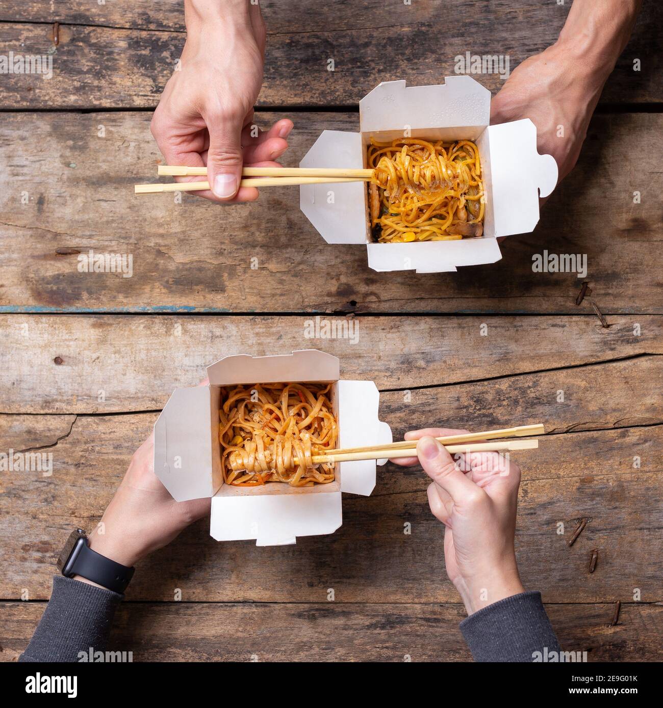Top view of couple eating chinese food from boxes Stock Photo